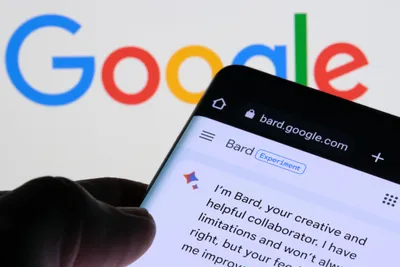A person holding a cell phone open to Google Bard in front of the Google homepage
