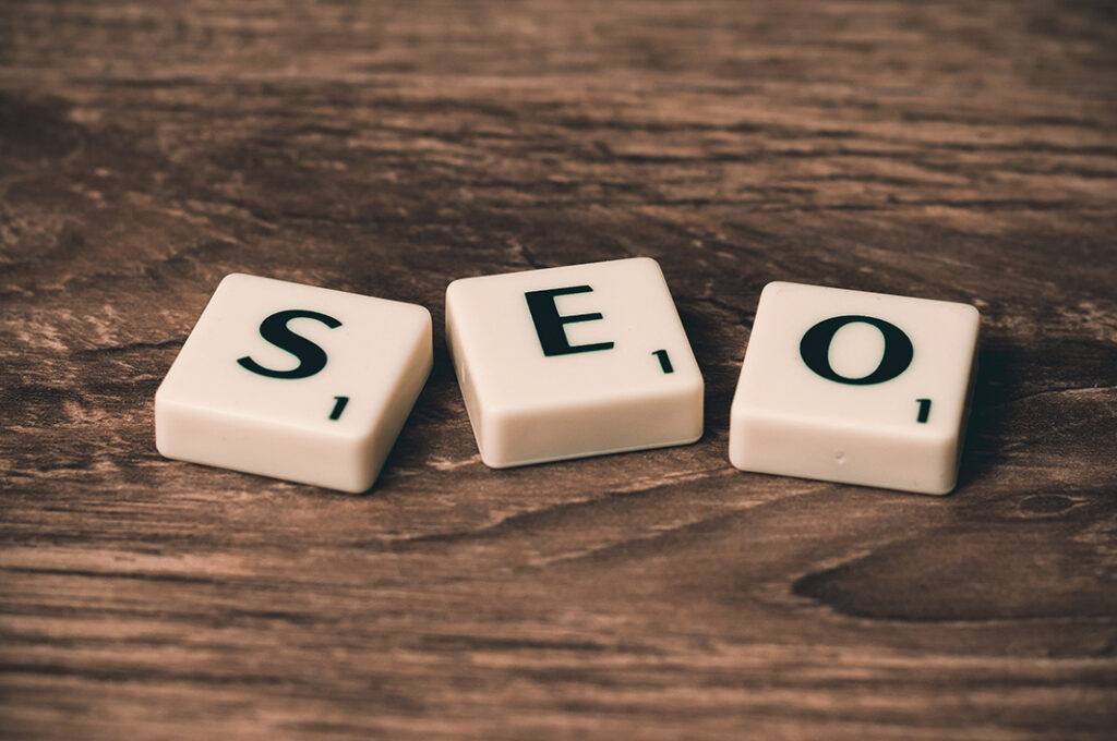 a wooden table topped with white dices that spell out the word seo